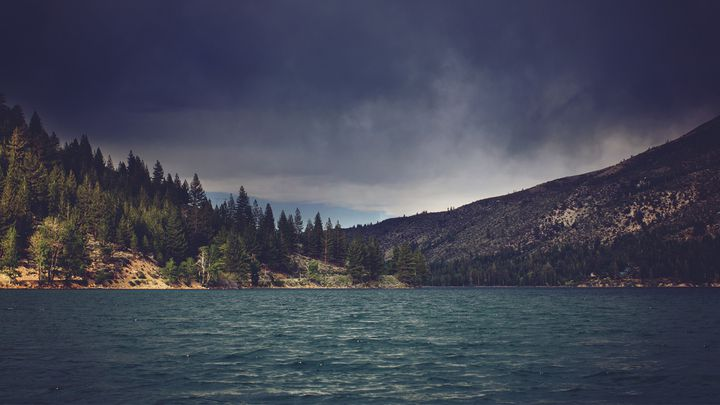 Storm clouds over a mountain lake, symbolizing division and the need for unity in the church